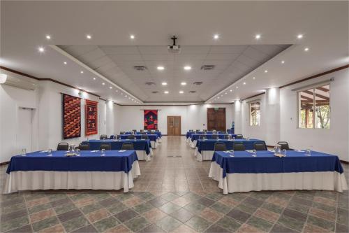 a room with blue tables and chairs in it at San Jose de Puembo Quito Airport, an Ascend Collection Hotel in Puembo