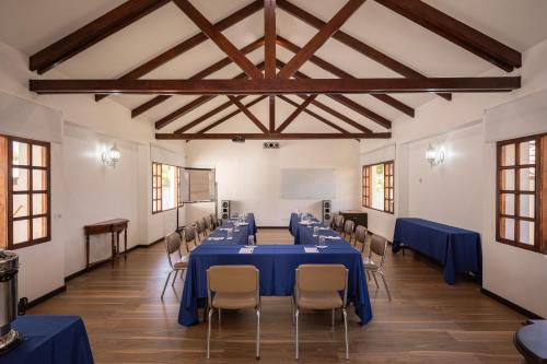 a large room with blue tables and chairs at San Jose de Puembo Quito Airport, an Ascend Collection Hotel in Puembo