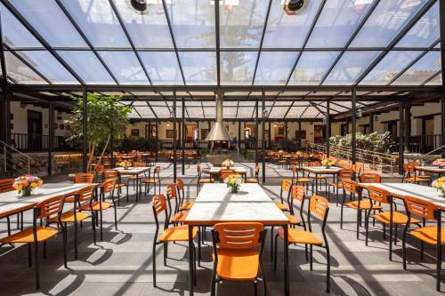 a restaurant with tables and chairs and a glass ceiling at San Jose de Puembo Quito Airport, an Ascend Collection Hotel in Puembo