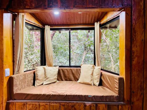 a couch in a room with a window at Cabañas La Montaña in Monteverde Costa Rica