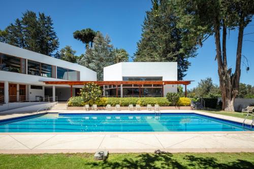 an exterior view of a house with a swimming pool at San Jose de Puembo Quito Airport, an Ascend Collection Hotel in Puembo