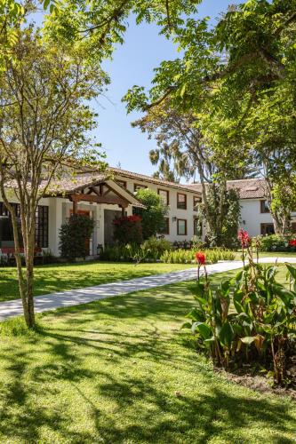 a house with a tree and a road at San Jose de Puembo Quito Airport, an Ascend Collection Hotel in Puembo