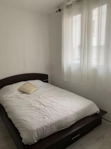 un lit dans une chambre blanche avec une fenêtre dans l'établissement Studio en plein centre ville, à Quimper