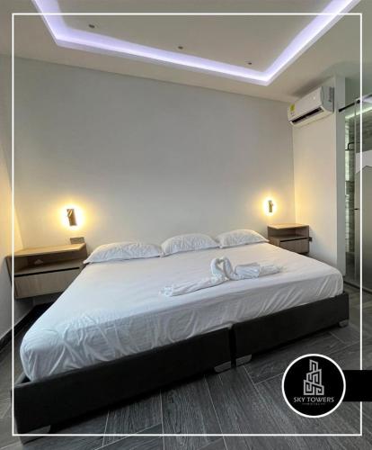 a bedroom with a large white bed with lights on it at Sky Towers in Cúcuta