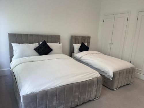 dos camas sentadas una al lado de la otra en un dormitorio en Kensington Luxury Apartments, en Londres