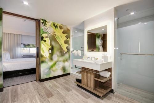 a bathroom with a sink and a shower and a mirror at Wyndham Garden Sacramento Airport Natomas in Sacramento
