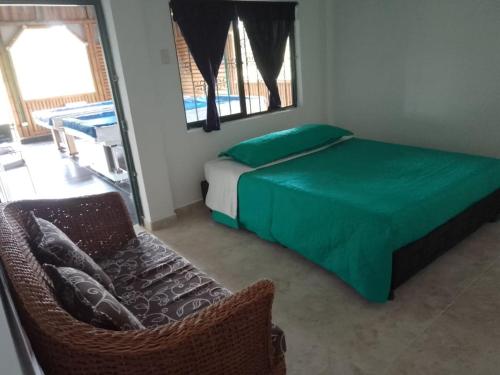1 dormitorio con cama, silla y espejo en Alojamiento Rural - La Perla, en Filandia