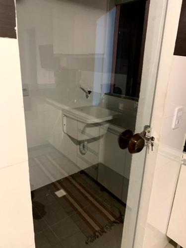 bagno con lavandino e porta bianca di Porto Home - AP 2 quartos a Porto Seguro