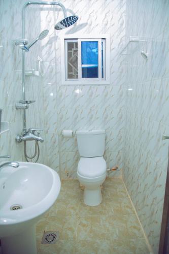 y baño con aseo blanco y lavamanos. en SeneGambia Beach Apartment, en Amdalai