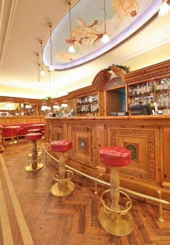 a bar with red stools in a restaurant at TH Madonna di Campiglio | Golf Hotel in Madonna di Campiglio