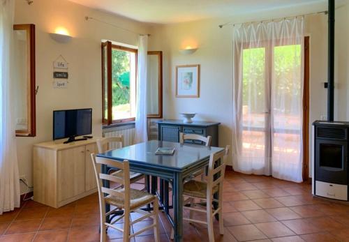 a kitchen with a table and chairs and a television at Belvedere Residenza Mediterranea in Portoferraio