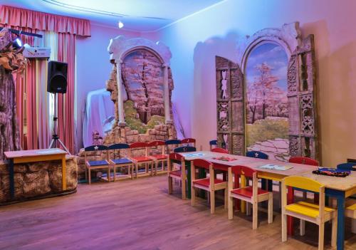 a room with tables and chairs and a painting on the wall at TH Madonna di Campiglio | Golf Hotel in Madonna di Campiglio