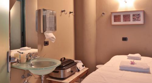 a hospital room with a sink and a bed at TH Madonna di Campiglio | Golf Hotel in Madonna di Campiglio