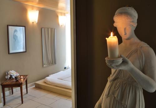 a statue of a woman holding a candle in a room at TH Madonna di Campiglio | Golf Hotel in Madonna di Campiglio
