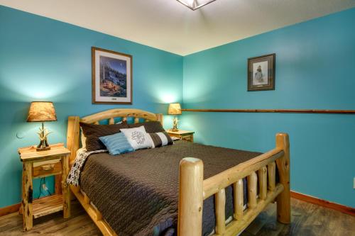 a bedroom with a wooden bed with blue walls at Pokegama Lake Vacation Rental with Shared Boat Dock! in Grand Rapids