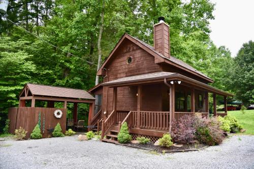 a small wooden house with a porch and a gazebo at CREEKSIDE Tiny Cabin by Pigeon Forge in Sevierville