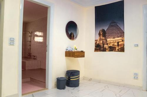 ein Bad mit einer Dusche und einem Wandspiegel in der Unterkunft Royal Pyramids Museum Guest House in Kairo