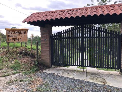 una puerta con un cartel delante de una valla en Alojamiento Rural - La Perla, en Filandia