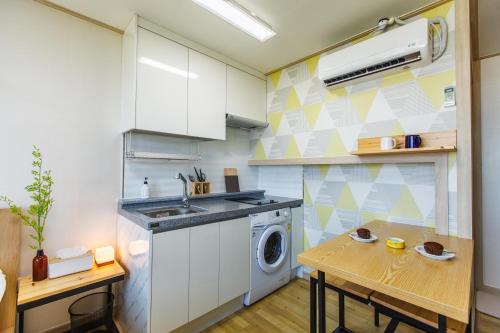 a kitchen with a sink and a washing machine at BnSun Pension in Seogwipo