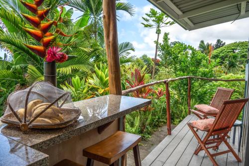 a porch with two chairs and a table on a porch at Gingerhill Farm Retreat in Kealakekua