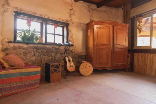 um quarto com uma guitarra ao lado de um armário e um guitarrista em Espacio Circular em San Marcos Sierras