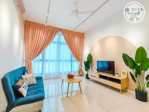 sala de estar con sofá azul y TV en Skudai Paradigm Mall by JBcity Home, en Johor Bahru