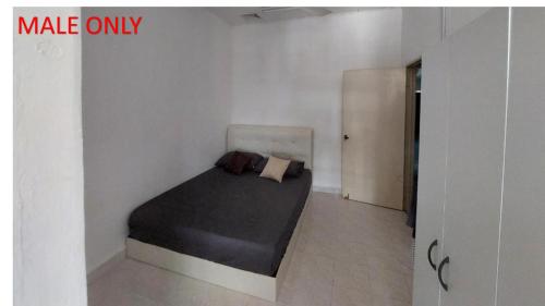 1 dormitorio con 1 cama en una habitación blanca en Roomstay Fiq, en Kulim