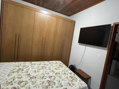 a bedroom with a bed and a flat screen tv at Casa Almeida in Tiradentes