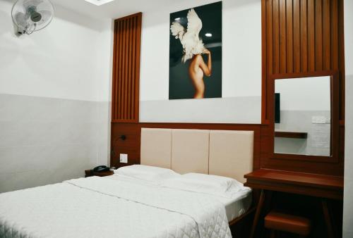 - une chambre avec un lit et une photo de femme dans l'établissement Tulip Hotel, à Hô-Chi-Minh-Ville