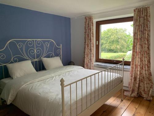 ビューリンゲンにあるHoliday home for 8 people in the Belgian Ardennesの青いベッドルーム(ベッド1台、窓付)