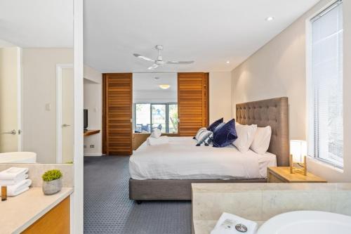 a bedroom with a large bed and a bathroom at Beachside Bliss 1 Bedroom Park View Villa in Mandurah