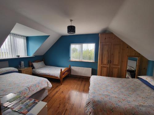 a bedroom with two beds and blue walls at Castleview in Milltown