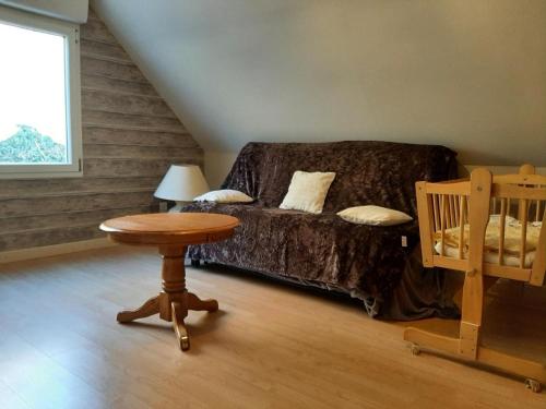 een woonkamer met een bank en een tafel bij Gîte chaleureux avec jardin, poêle à bois et wifi, entre St Omer et Boulogne sur Mer - FR-1-376-80 in Coulomby