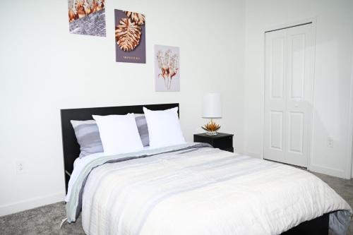 a white bedroom with a large bed with white pillows at Luxurious 8-Room Oasis near Disney in Kissimmee