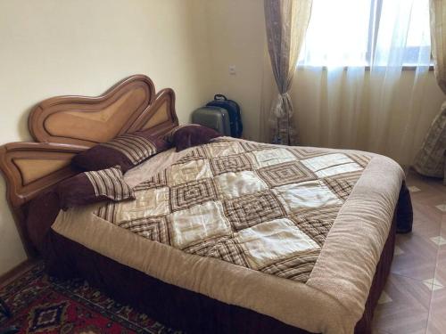 a bedroom with a bed with a quilt on it at Собственный дом в фруктовом саду 