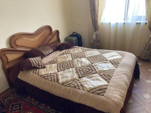 ein Schlafzimmer mit einem Bett mit einer Steppdecke darauf in der Unterkunft Собственный дом в фруктовом саду in Katʼnaghbyur