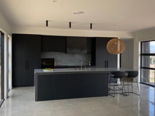a kitchen with black cabinets and a counter top at Cosy Kinloch in Kinloch