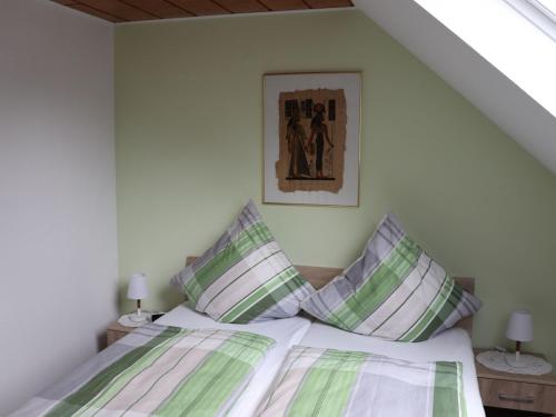 a bedroom with a bed with green and white pillows at Fewo-rosenberger-sauerland in Lennestadt