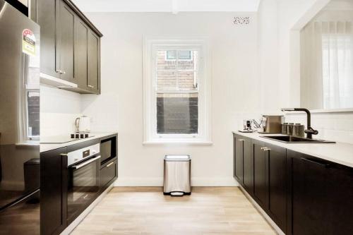 uma cozinha com electrodomésticos a preto e branco e uma janela em Sydney CBD Waterview Apartment 54A em Sydney