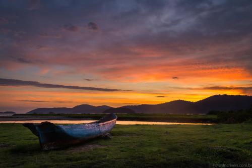 a boat sitting on the grass at sunset at Pousada Sambaki in Paraty