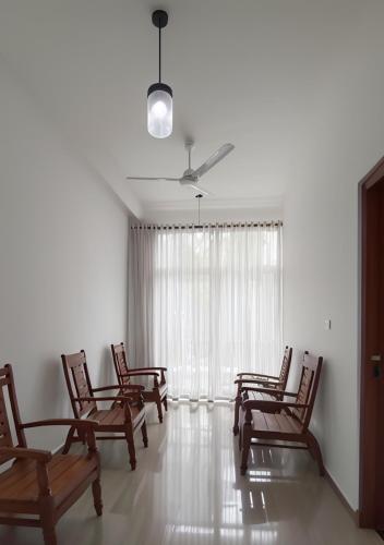 a group of chairs in a room with a window at Shine Ray VILLA in Galle
