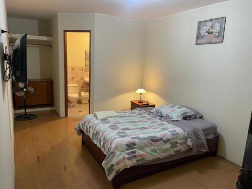 une chambre avec un lit et une télévision dans l'établissement Entre Cava y Cata, à Ica