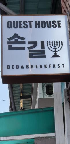 un cartel para un hostal con las palabras "hostal" antes del desayuno en Son-Gil Guesthouse en Jinju