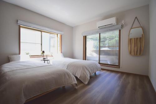 2 camas en una habitación con ventana en にし阿波ねすと, en Higashimiyoshi