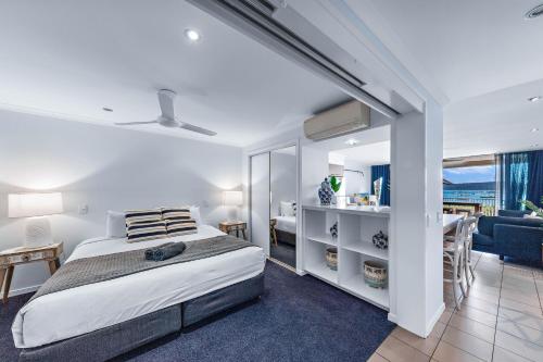 Un dormitorio con una cama y una sala de estar. en By The Sea Shore With Pool, en Airlie Beach