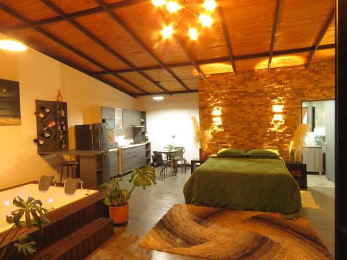 a bedroom with a large bed and a kitchen at San Simon Glamping,El peñol,Guatape in Guatapé