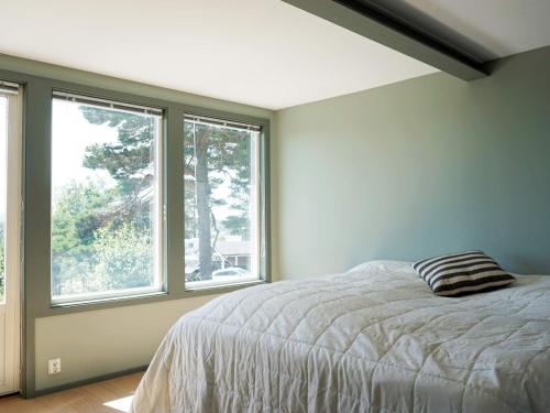 ein Schlafzimmer mit einem Bett und zwei Fenstern in der Unterkunft 4 star holiday home in STRÖMSTAD-By Traum in Strömstad