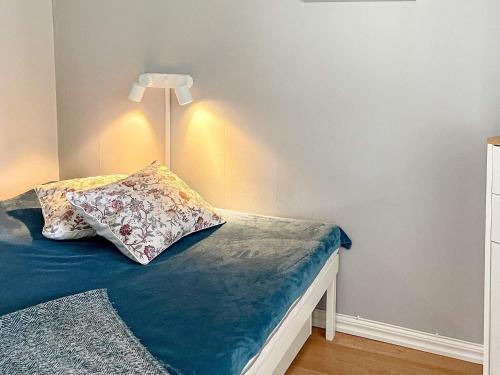 a bed with a lamp and a pillow on it at Holiday home KARLSHAMN III in Karlshamn