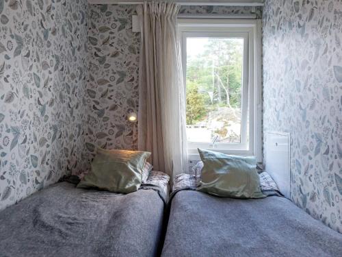 a bedroom with two beds and a window at Holiday home Grebbestad XII in Grebbestad