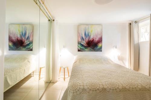 a bedroom with two beds and two paintings on the wall at Tafat's Haven Lodge in Nurit